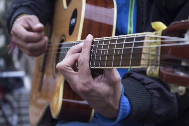 Adam akustik gitar çalıyor.