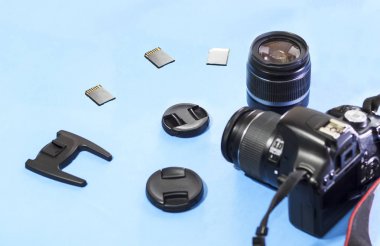Fotoğraf makinesi, objektif, bellek sürücüsü mavi bir arka plan üzerinde yakın çekim