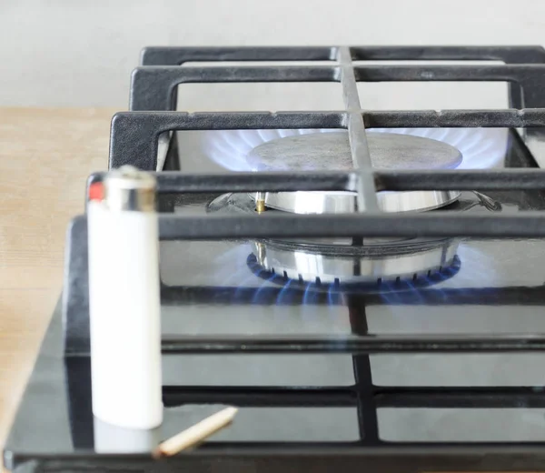 Estufa de gas. Encendedor y un fósforo quemado en el centro de atención — Foto de Stock