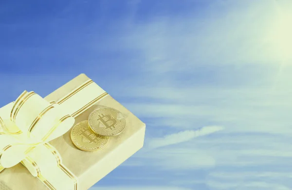 Bitcoin moeda eletrônica em uma caixa de papel em um estilo antigo, contra um fundo azul céu — Fotografia de Stock
