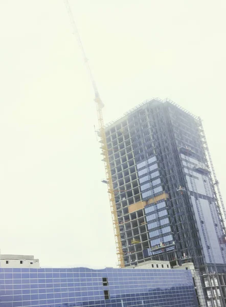 Edificio, rascacielos. Está hecho de hormigón y vidrio. Grúa al aire libre — Foto de Stock