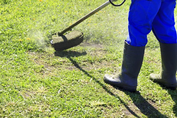 Ein Mann im blauen Anzug. mit Schutzhelm und Kopfhörer. produziert Kräuter ernten. das Gesicht nicht fokussiert — Stockfoto