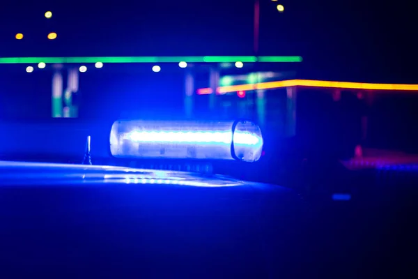 La nuit. voiture de police bleue avec mise au point sélective et flou bokeh . — Photo