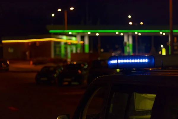 De noite. carro de polícia azul com foco seletivo e bokeh borrão . — Fotografia de Stock