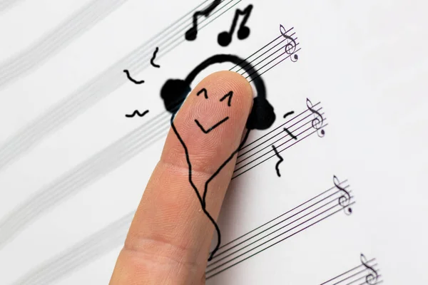 Konzept. Der Finger liegt auf Noten und hört Musik. Er ist zufrieden. — Stockfoto