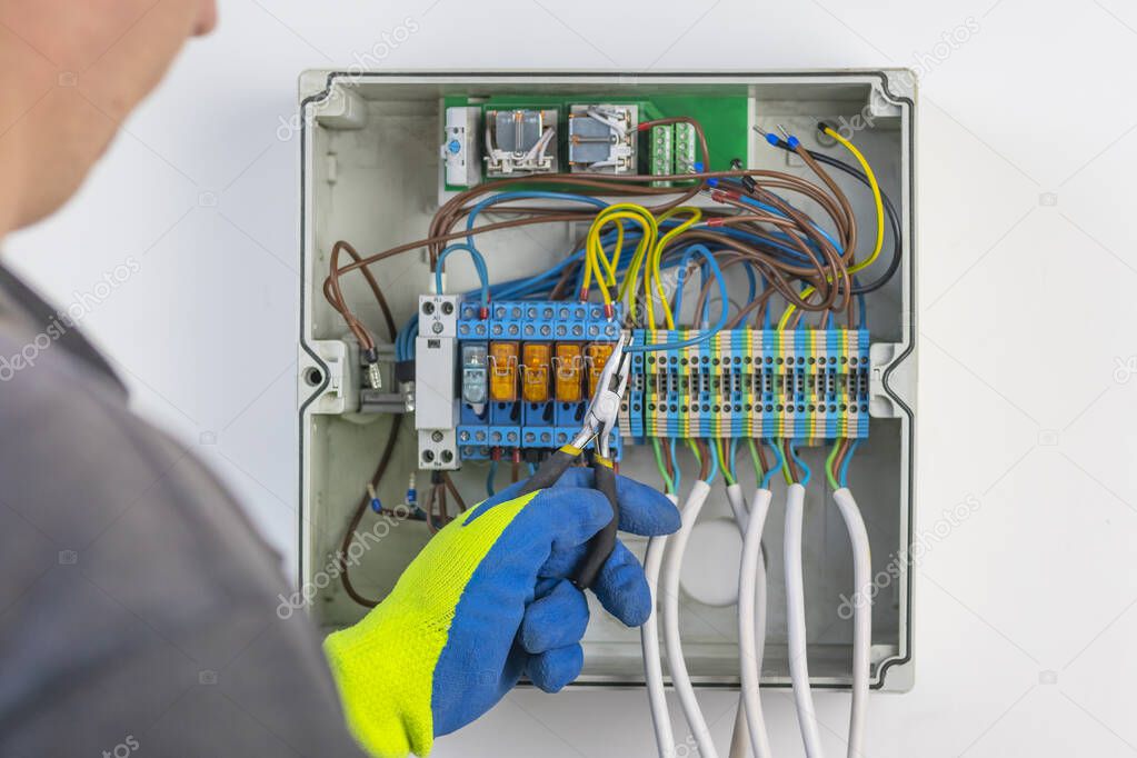 with the help of wire cutters, the master places the wire in the socket. panel board. not only electricity and internet control are mantled into it.