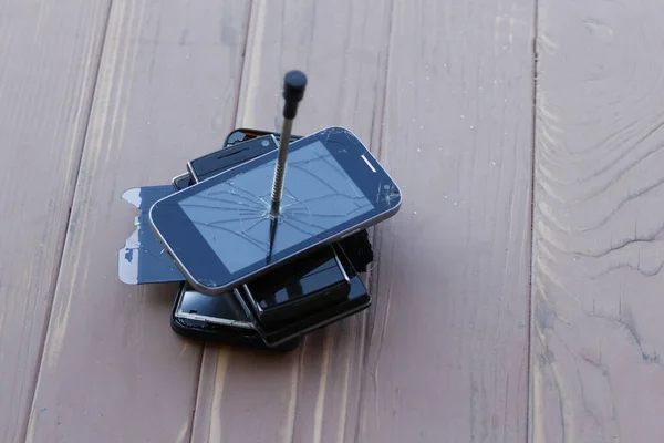 Smartphone se encuentra sobre un fondo de madera. está roto. primer plano . — Foto de Stock