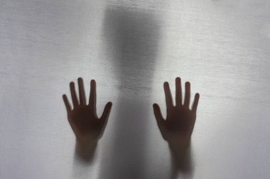 Odaklanma. Arkasındaki kumaş. Siluet ve gölge. Eli kumaşa değmiş çocuk, lütfen yardım et. aile içi şiddet kavramı.
