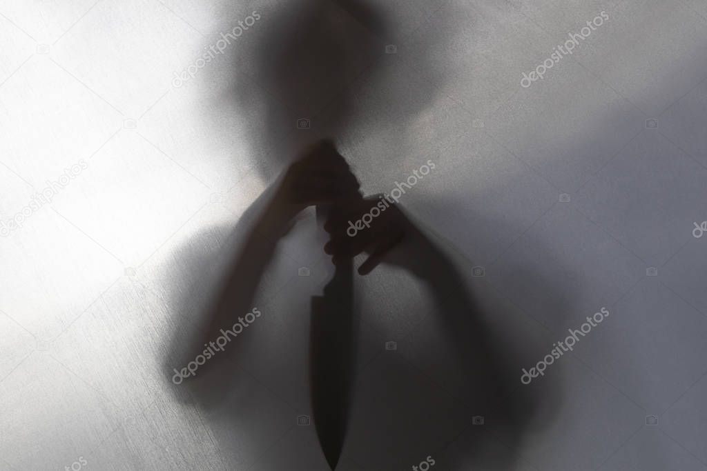 no focus. the fabric behind her. silhouette and shadow. the child has a knife in his hands. domestic violence concept.