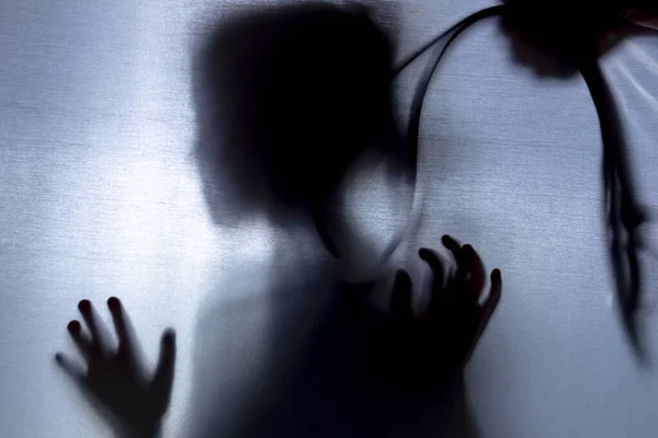 Nessuna concentrazione. il tessuto dietro di lei. silhouette e ombra. bambino sopra la cinghia della testa. concetto di violenza domestica . — Foto Stock