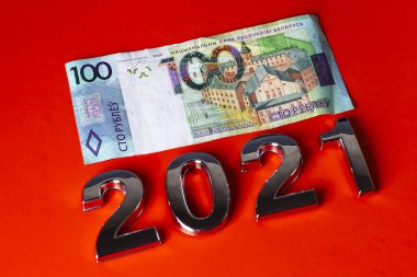 Faturası 100 ruble. Turuncu bir arka planda. Metalik parıltılı 2021 sayıları serilmiştir. yakın plan.