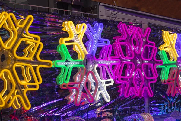 Nahaufnahme. Neon-Schneeflocke. auf Folienhintergrund. gemacht in völliger Dunkelheit. — Stockfoto
