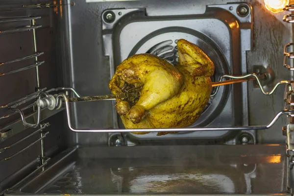 Forno. frango grelhado é cozido em uma saliva. gira gradualmente na vertical — Fotografia de Stock