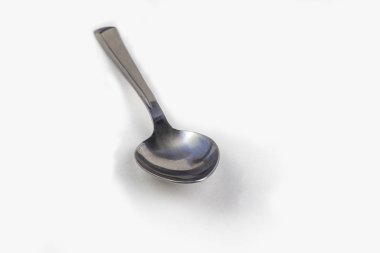 Yakın plan. Beyaz arka planda boş çelik kaşık. izolasyon.