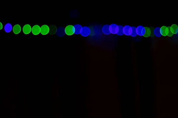 no focus, black background. lights, garland. different color. place for text.