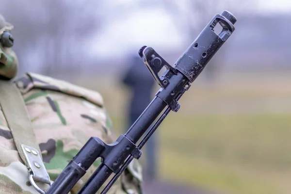 Close-up, Kalashnikov aanvalsgeweer, op de borst van een militair. Er is een tint. — Stockfoto