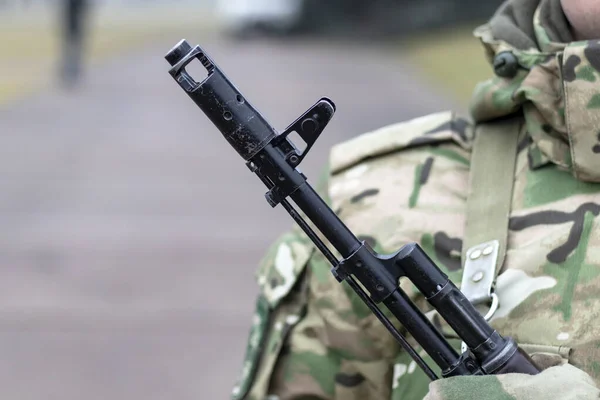 De perto, espingarda de assalto Kalashnikov, no peito de um militar. Há uma tonalidade — Fotografia de Stock