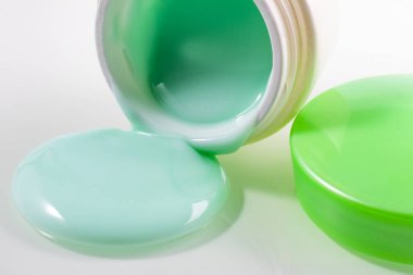 Kremalı ve yeşil kapaklı bir kavanoz. Banka açık ve yakınlarda bir gemi gezisi var. Yakın plan. beyaz arkaplan.