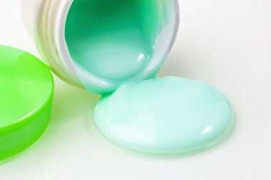 Kremalı ve yeşil kapaklı bir kavanoz. Banka açık ve yakınlarda bir gemi gezisi var. Yakın plan. beyaz arkaplan.