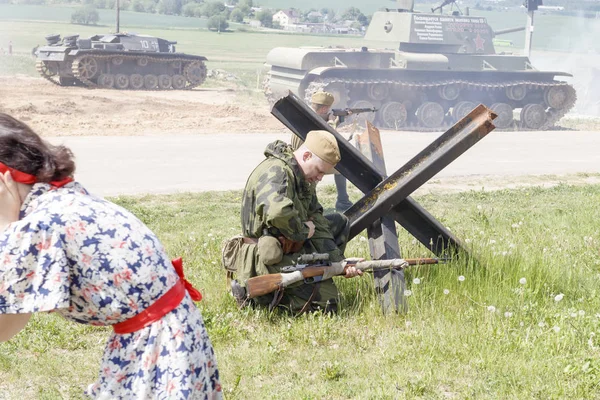 Minsk. Bielorrússia. 25 de maio de 2019. Descrição dos acontecimentos da Segunda Guerra Mundial. Civil em pânico foge da explosão. O atirador está se preparando para o tiro. — Fotografia de Stock