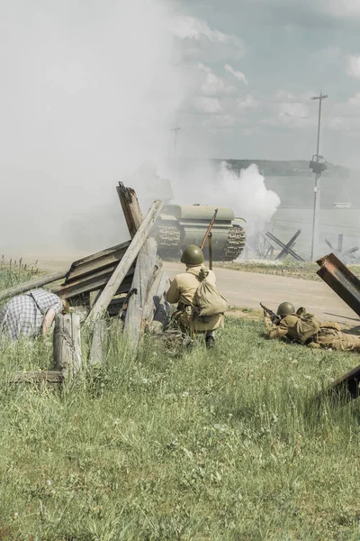 dramatizasyon. büyük vatansever savaşta bir tüfek tutan asker. bir sürü duman var. siviller var.