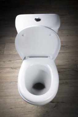 Tuvalet beyaz. Eski tarz tahtalardan yapılma zeminde duruyor. yakın plan.