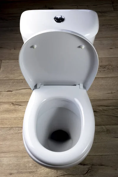 The toilet is white. he is standing on the floor made of retro style boards. close-up. — Stock Photo, Image