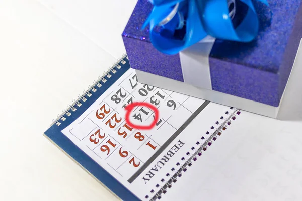 O calendário da secretária tem um número vermelho 14. Tem uma caixa de presente ao lado. . — Fotografia de Stock