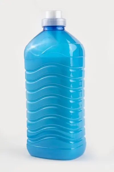 En plastflaska fylld med blå vätska. På vit bakgrund. Närbild — Stockfoto