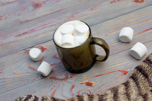Marshmallow. Gaya Retro Latar belakang kayu. Gelas cangkir dengan marshmallow di dalamnya. Ada juga selendang wol. Close-up. Dicat — Stok Foto