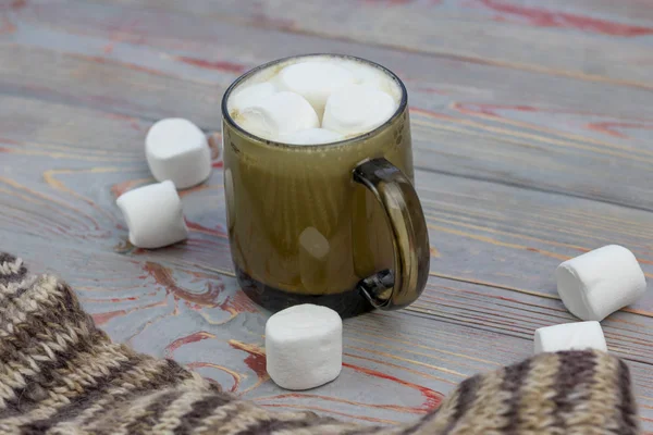 Marshmallow. Retro stil trä bakgrund. En glasmugg med marshmallow i. Det finns också en yllesjal. Närbild. Tecknad — Stockfoto