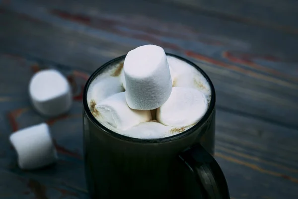 Marshmallow. Gaya Retro Latar belakang kayu. Gelas cangkir dengan marshmallow di dalamnya. Ada juga selendang wol. Close-up. Dicat — Foto Stok Gratis