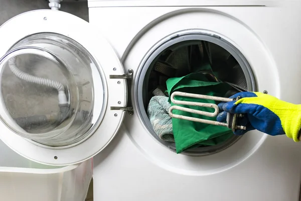 Panne de machine à laver. Le capitaine récupère la partie du plancher. Dans les mains d'une clé spirale et réglable. Gros plan — Photo