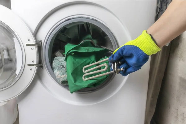 Panne de machine à laver. Le capitaine récupère la partie du plancher. Dans les mains d'une clé spirale et réglable. Gros plan — Photo