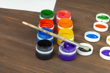 Eski tarz ahşap arka plan. Kutularda boya ve boya fırçası var. Yakın plan. Renkli