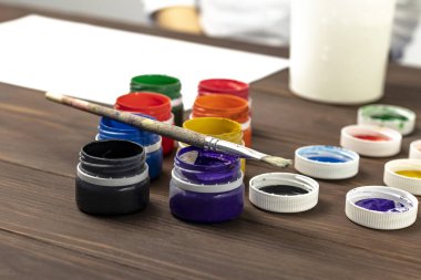 Eski tarz ahşap arka plan. Kutularda boya ve boya fırçası var. Yakın plan. Renkli