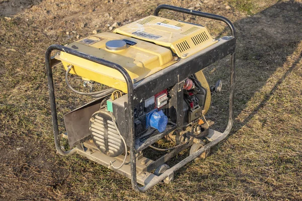 Zbliżenie. Oświetlenie ulicy. Zasilany benzyną generator, który wytwarza prąd. Zapasowe lub awaryjne źródło zasilania. Generator nie jest nowy. — Zdjęcie stockowe