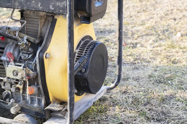 Zbliżenie. Oświetlenie ulicy. Zasilany benzyną generator, który wytwarza prąd. Zapasowe lub awaryjne źródło zasilania. Generator nie jest nowy. — Zdjęcie stockowe