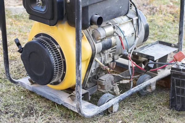 Zbliżenie. Oświetlenie ulicy. Zasilany benzyną generator, który wytwarza prąd. Zapasowe lub awaryjne źródło zasilania. Generator nie jest nowy. — Zdjęcie stockowe