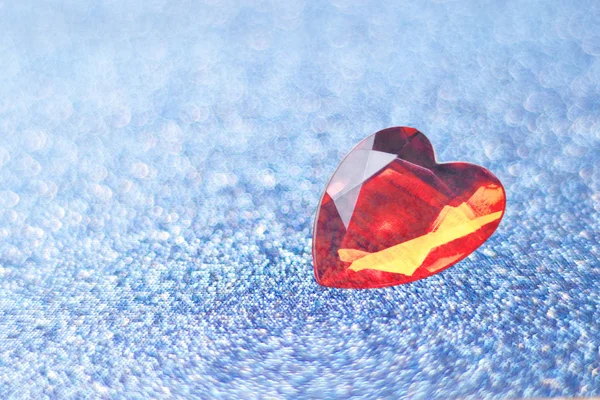 Blauer Hintergrund mit Funkeln mit geringer Schärfentiefe. Weichzeichner. rotes Herz. Kopierraum. — Stockfoto