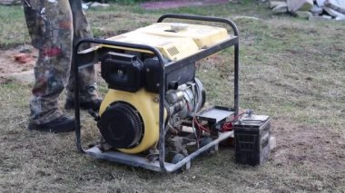 Yakın plan. Usta, istasyonu elle çalıştırarak elektrik üretmeye başlar..