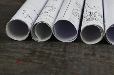 Ahşap arka plan. Üzerinde planlar, gelecekteki evin planı ya da bilgisi var. Sarınmışlar..