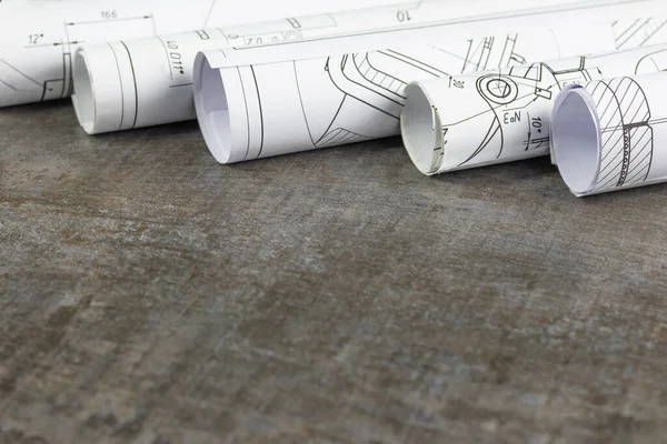 Wooden background. On it are blueprints or a plan of the future home or knowledge. They are rolled up. — Stock Photo, Image