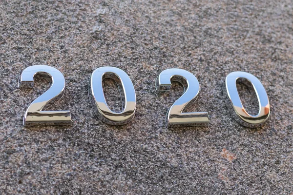 2020 anno cifre in metallo. Stesi sulla pietra. Profondità di campo ridotta. C'è una tinta. — Foto Stock