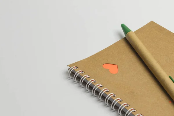 Notebook with hearts on it a pen and shot on a white background. Close-up. Copy space — Stock Photo, Image