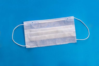 medical mask for protection against bacteria. On a blue background. Close-up
