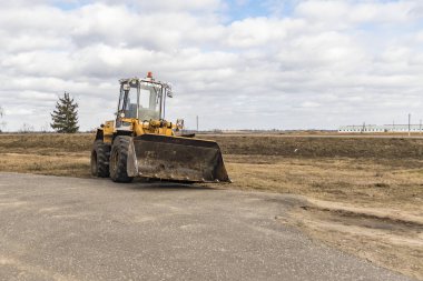 Sarı Gün Işığı Yükleyicisi bir kova ile. Rengi var. Yakın plan..