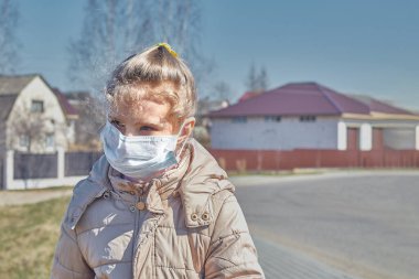 Beyaz saçlı, ceketli ve tıbbi maskeli bir çocuk. Okula devamsızlık yasağı. izolasyon.