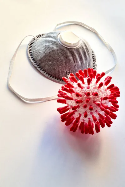 On a white background a medical mask and a model of a virus molecule. Close-up. Dust mask