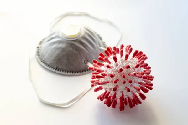 On a white background a medical mask and a model of a virus molecule. Close-up. Dust mask